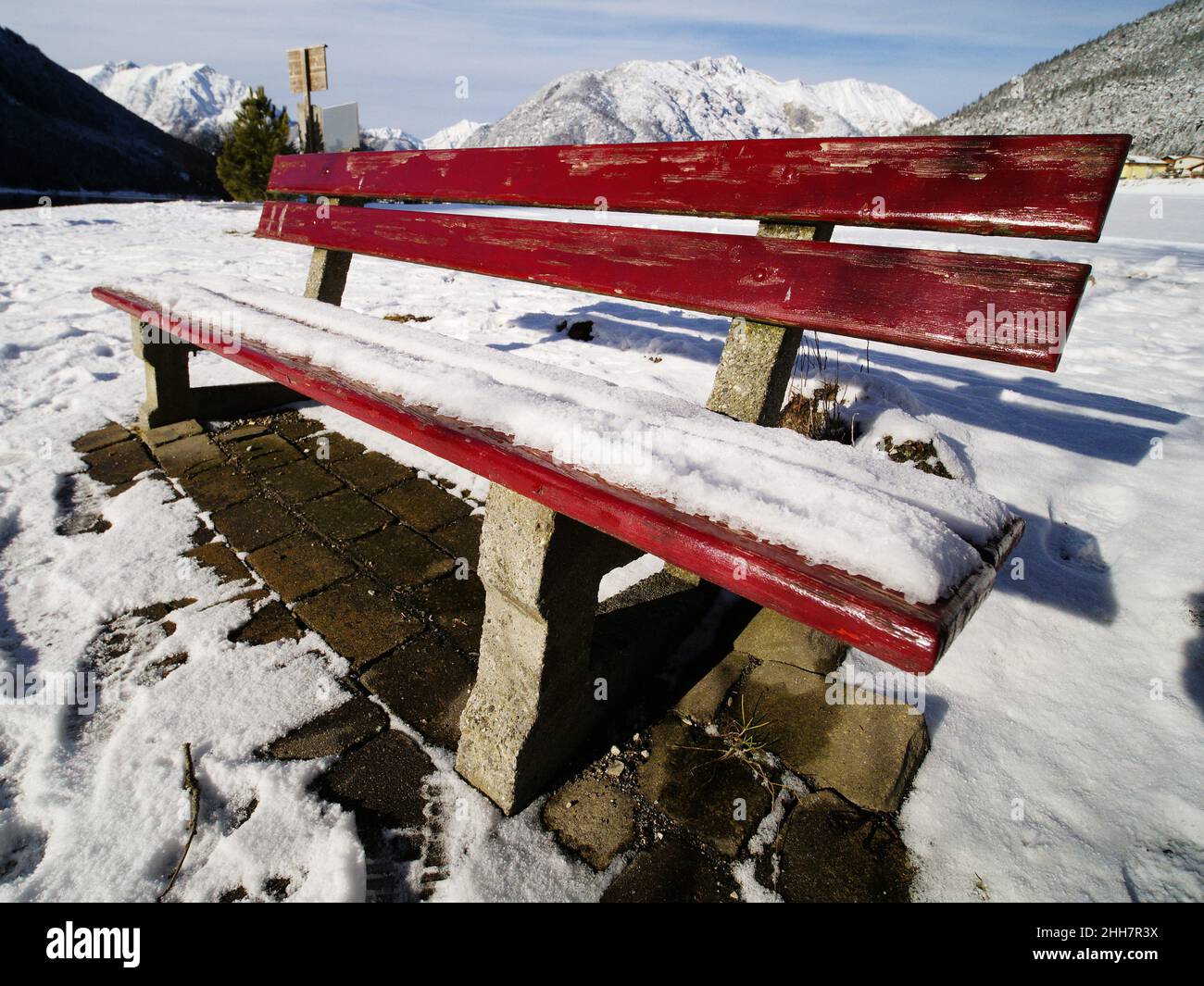 Red bench, sunny winter day, Lake Achen, Austria Stock Photo