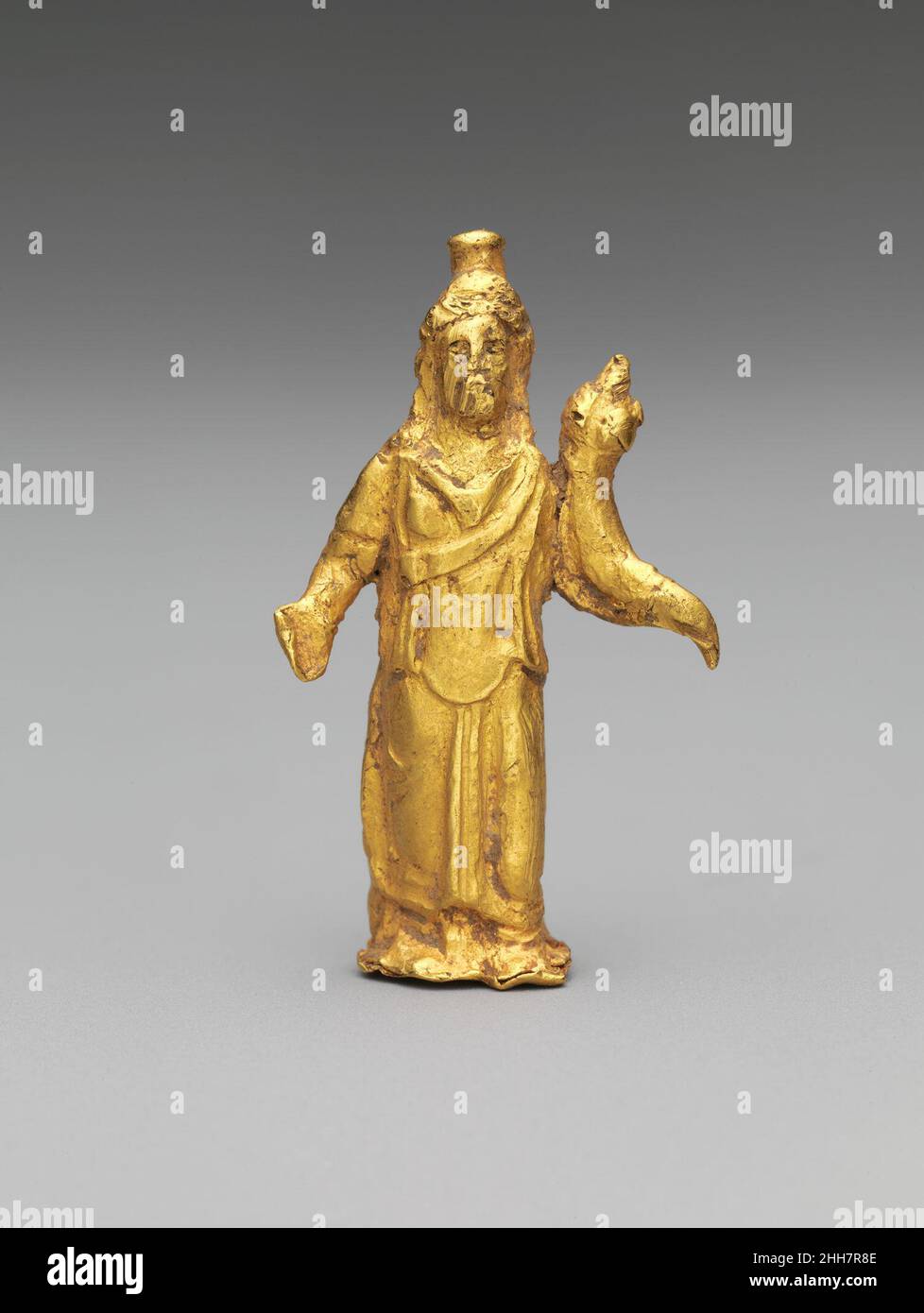 Gold statuette of Zeus Serapis 2nd century A.D. Roman Serapis was essentially a construct of the Ptolemaic Greek rulers of Egypt, a conflation of the local gods Osiris and Apis. Although gradually subsumed into the all-pervading cult of Isis, Serapis was worshipped throughout the Roman world in the guise of Zeus, ruler of the heavens, or that of Hades, god of the Underworld. This small figure wears the Egyptian modius (grain measure) headdress and carries a cornucopia (horn of plenty) to symbolize a plentiful food supply.. Gold statuette of Zeus Serapis. Roman. 2nd century A.D.. Gold. Mid-Impe Stock Photo