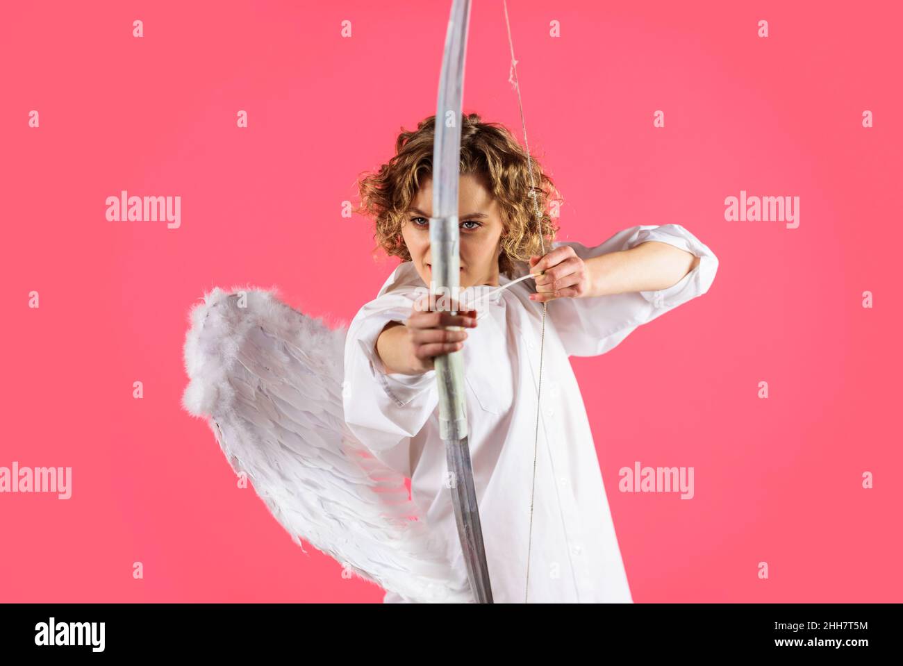 Valentines day angel. Cupid girl with bow and arrow. Curly woman in white wings. Happy holidays Stock Photo