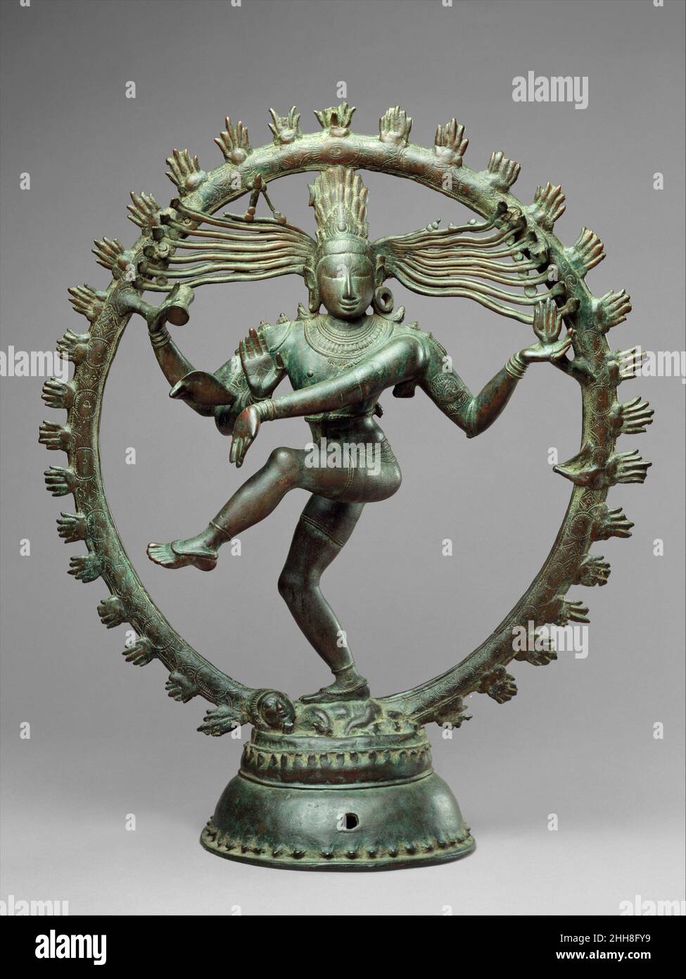 Shiva as Lord of Dance (Nataraja) ca. 11th century Indian (Tamil Nadu) As a symbol, Shiva Nataraja is a brilliant invention. It combines in a single image Shiva's roles as creator, preserver, and destroyer of the universe and conveys the Indian conception of the never-ending cycle of time. Although it appeared in sculpture as early as the fifth century, its present, world-famous form evolved under the rule of the Cholas. Shiva's dance is set within a flaming halo. The god holds in his upper right hand the damaru (hand drum that made the first sounds of creation). His upper left hand holds agni Stock Photo