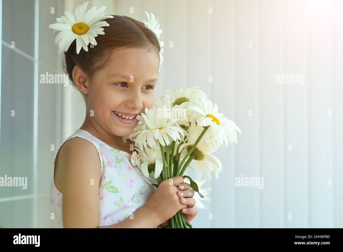 Cute little girl at home with chamomile Stock Photo - Alamy