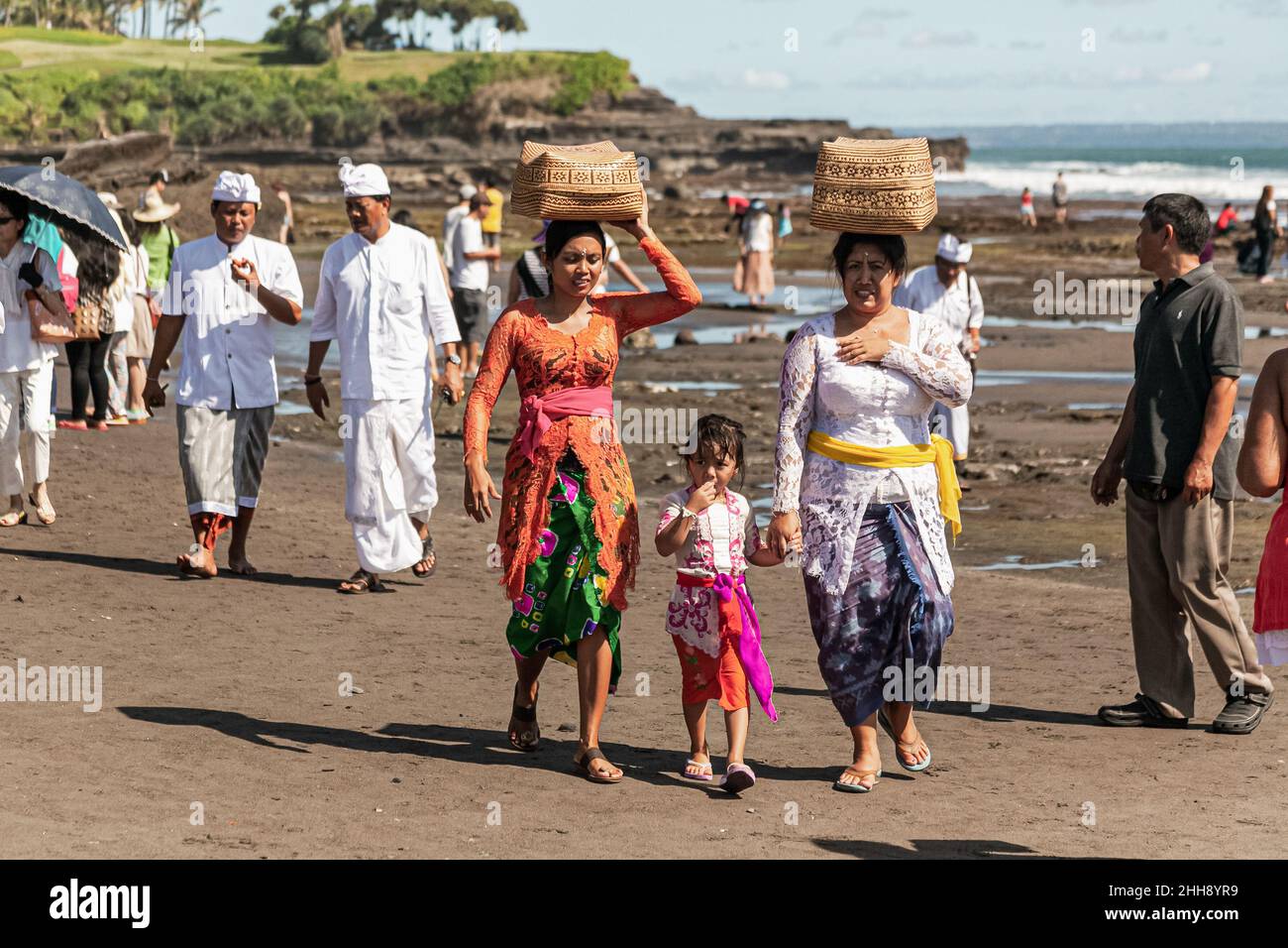 BALI, INDONESIA - MARCH 1, 2014: Local women carry offerings in the baskets on their head, Bali, Indonesia Stock Photo
