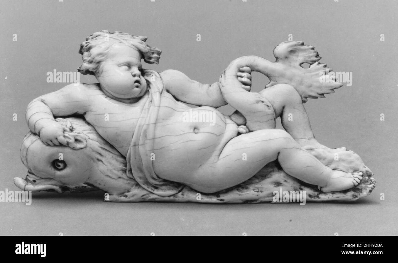 Putto on a Dolphin mid-17th century Circle of Gérard van Opstal Collectors in French courtly circles prized van Opstal's reworking in ivory of themes he employed in large-scale architectural reliefs carved for palaces and private mansions in Paris. The land- and sea-based mythological scenes in which he specialized were clearly inspired by his fellow Fleming Rubens, who was, in turn, inspired by antique Roman sarcophagi. Van Opstal's ivories are often pierced and evidently meant to be mounted against a dark background. This example, perhaps by a follower, may have been intended for an ebony ca Stock Photo