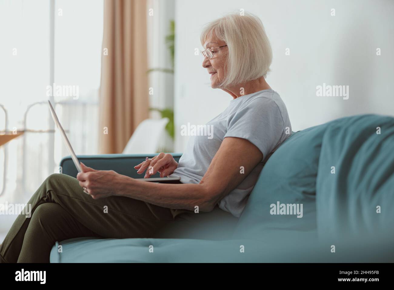 Modern old lady using laptop computer at home Stock Photo