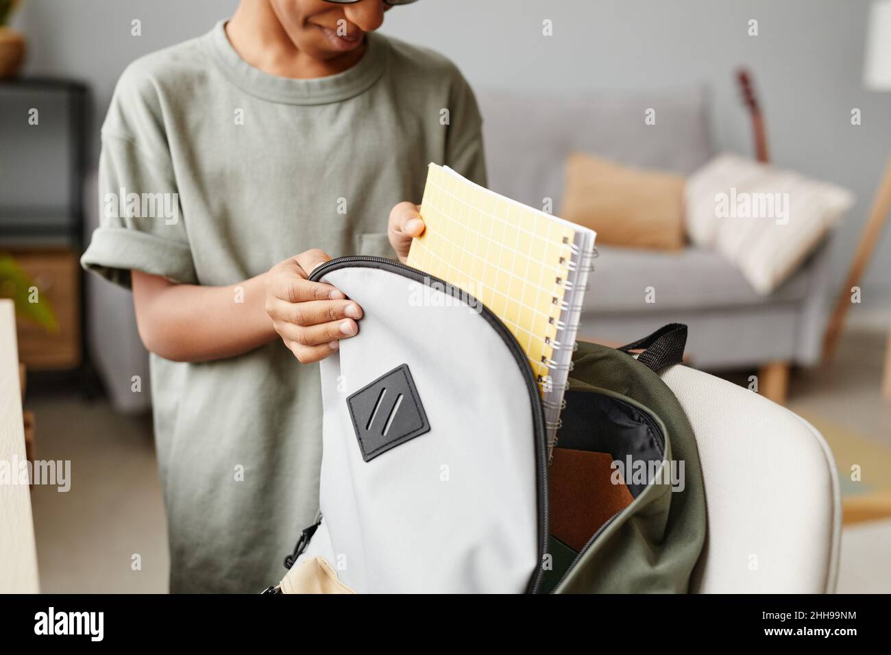 Close up of young African-American boy packing backpack at home, copy space Stock Photo