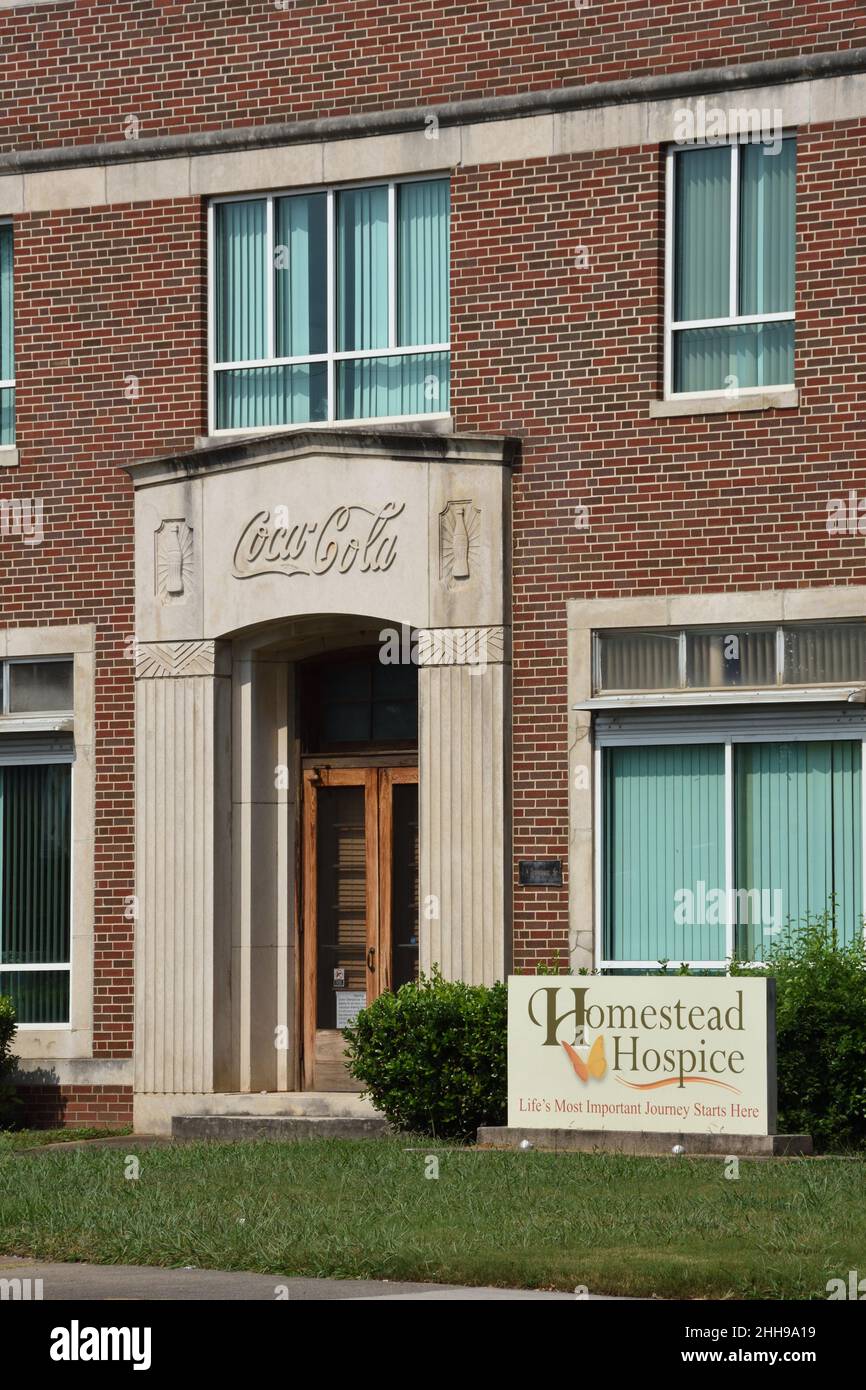The closeup of Coca Cola logo at the entrance of the old redbrick Coca