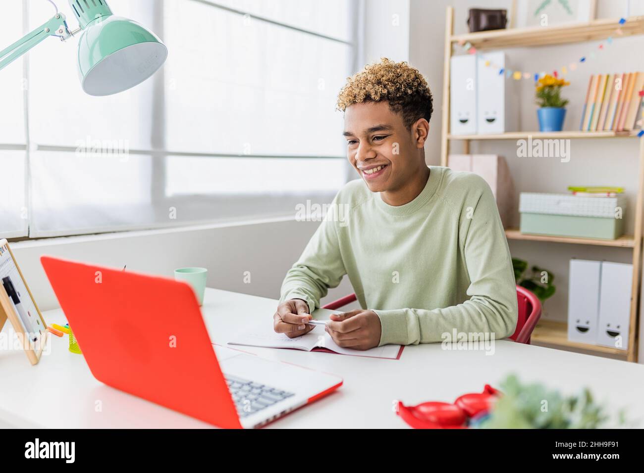 Smiling boy studying online from home having a video conference on laptop  Stock Photo