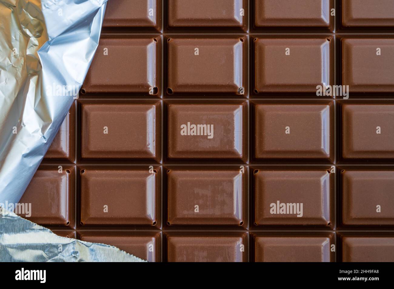 Chocolate bar with part of the silver wrapper Stock Photo - Alamy