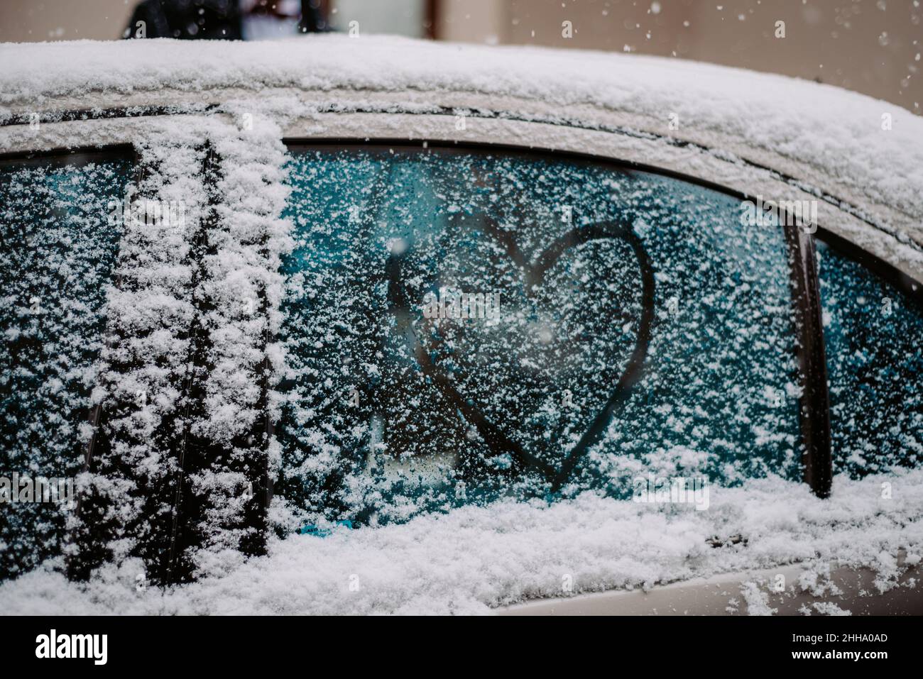 heart drawn on snow frozen car glass Stock Photo