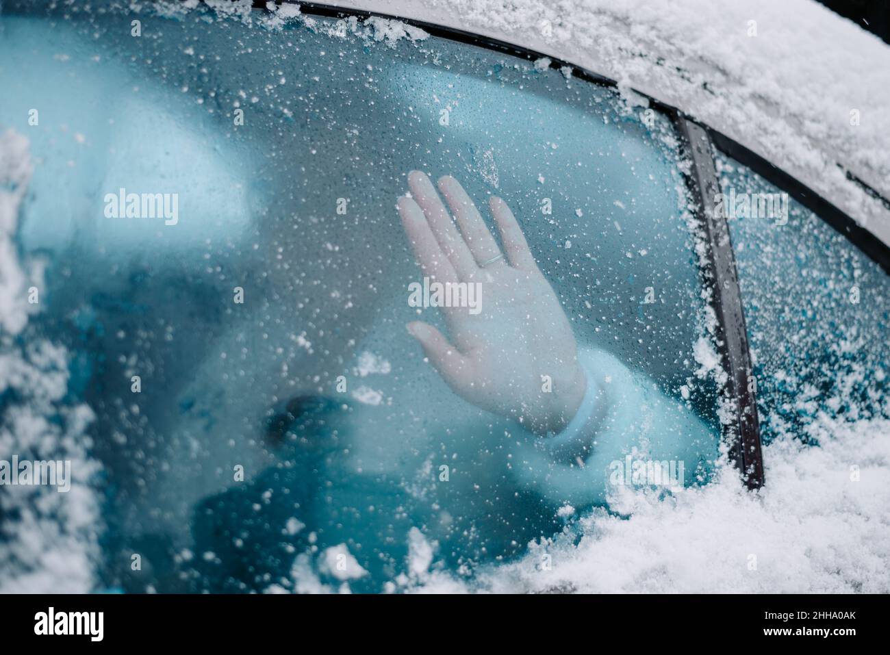 hand on frozen glass in the car, cold weather Stock Photo