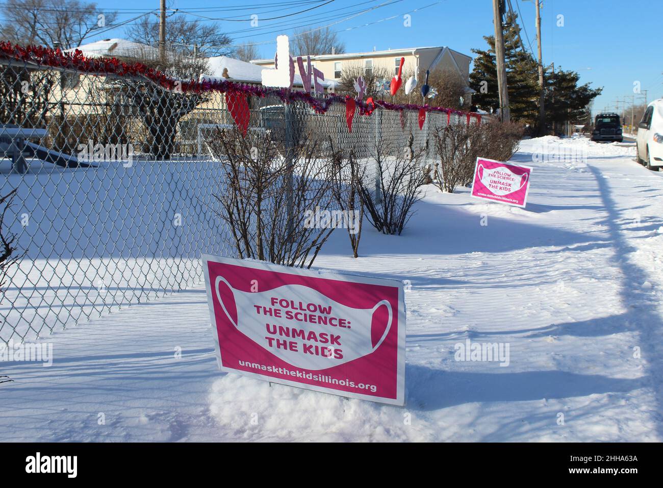 Follow the Science Unmask the Kids signs in the snow at Morton Grove, Illinois with valentines hearts Stock Photo