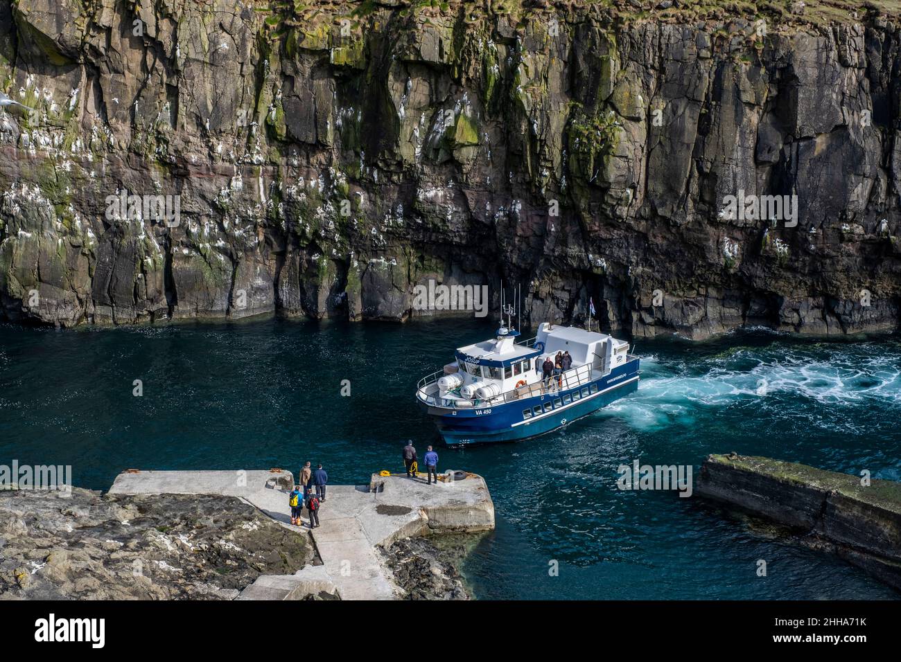 Ferry passes dramatic cliffs on its way to dock. Stock Photo