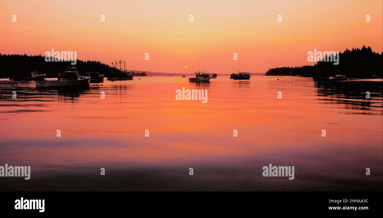 A New England harbor and fishing boats at sunset Stock Photo