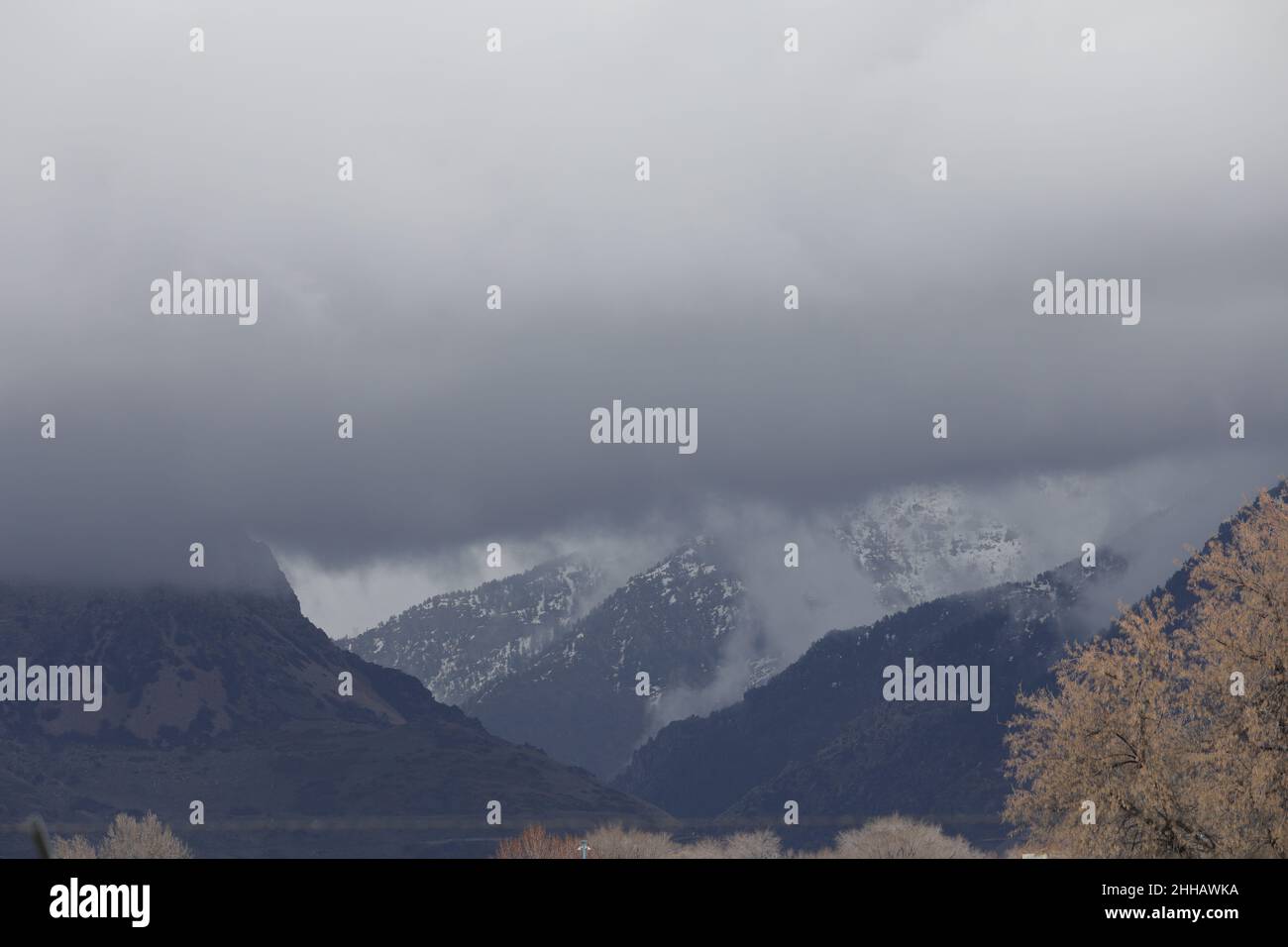 Clouds float around the Wasatch Mountains in Ogden Utah Stock Photo