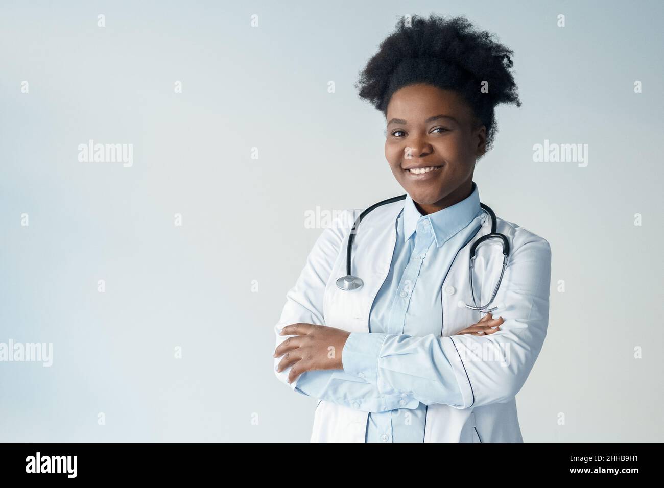 African American female doctor health worker with arms crossed portrait on grey Stock Photo