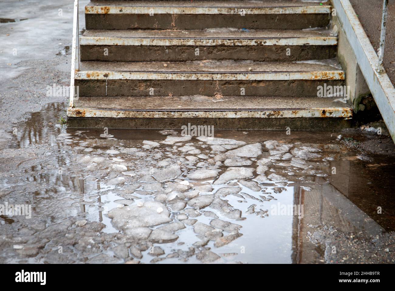 Dangerous and unsafe stairs. Melted snow, water and slippery. Concrete