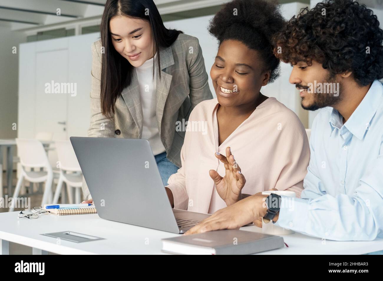 Interracial student colleague diverse group working on laptop together Stock Photo