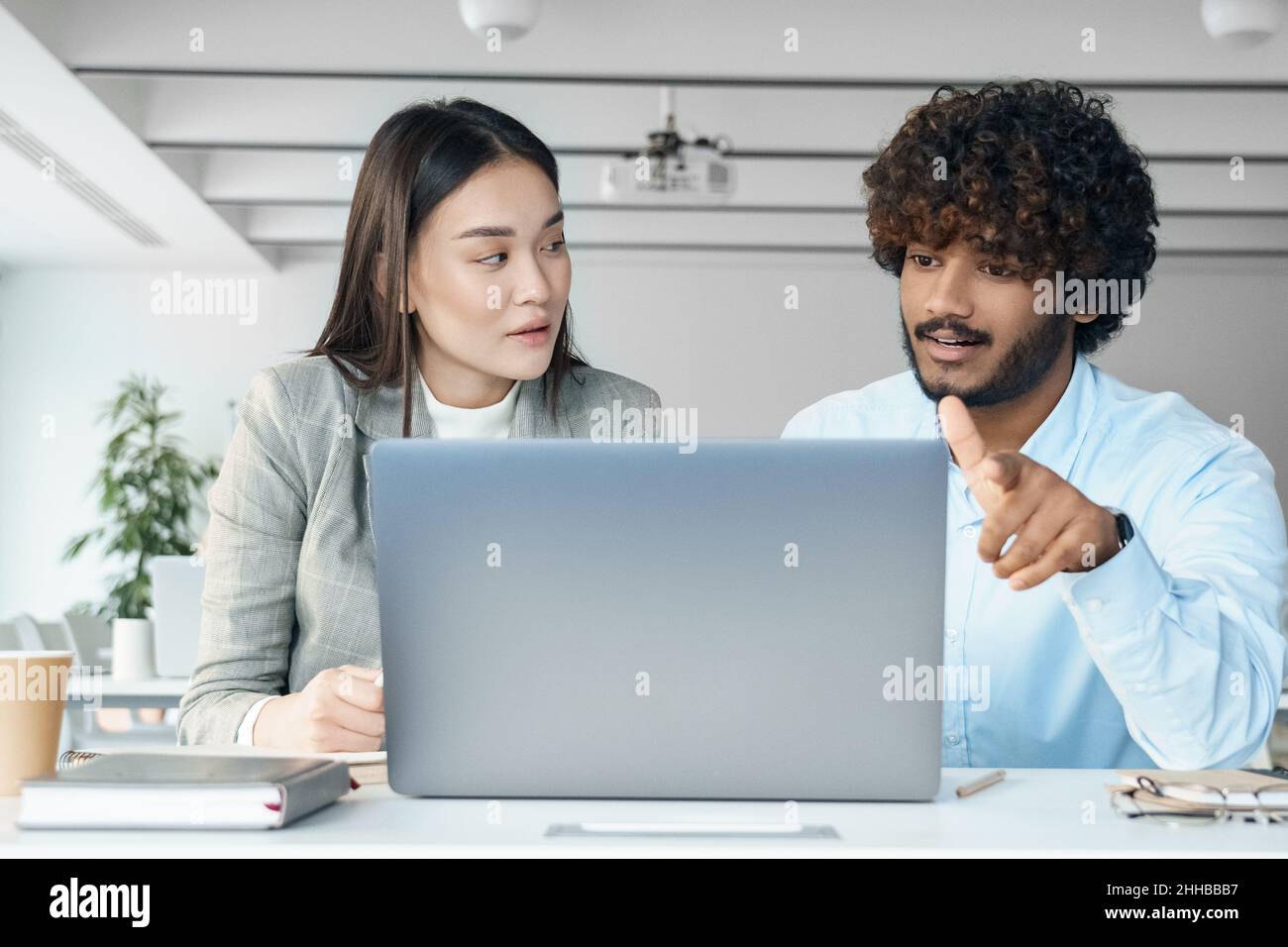 Two creative workers discussing online startup project looking at laptop screen Stock Photo