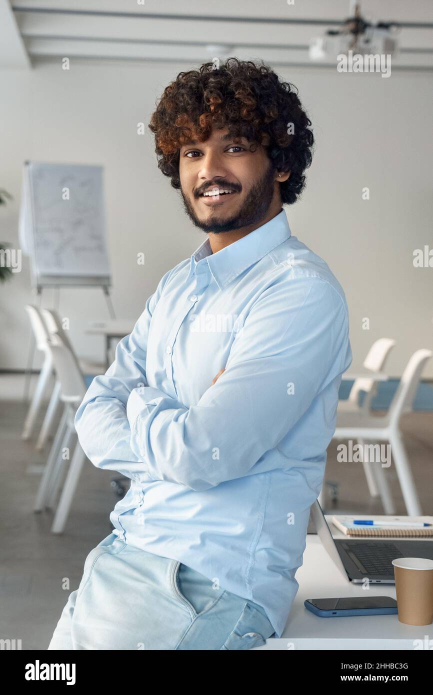 Portrait of happy smiling casual indian ethnic business man in boardroom Stock Photo