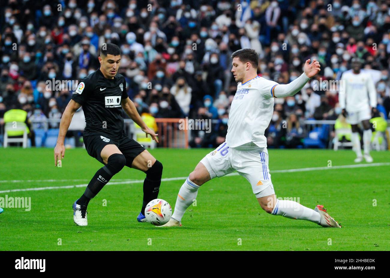 Madrid, Spain. 23rd Jan, 2022. Real Madrid's Luka Jovic (R) vies with Elche's Diego Gonzalez during a Spanish first division league football match between Real Madrid and Elche CF in Madrid, Spain, Jan. 23, 2022. Credit: Gustavo Valiente/Xinhua/Alamy Live News Stock Photo