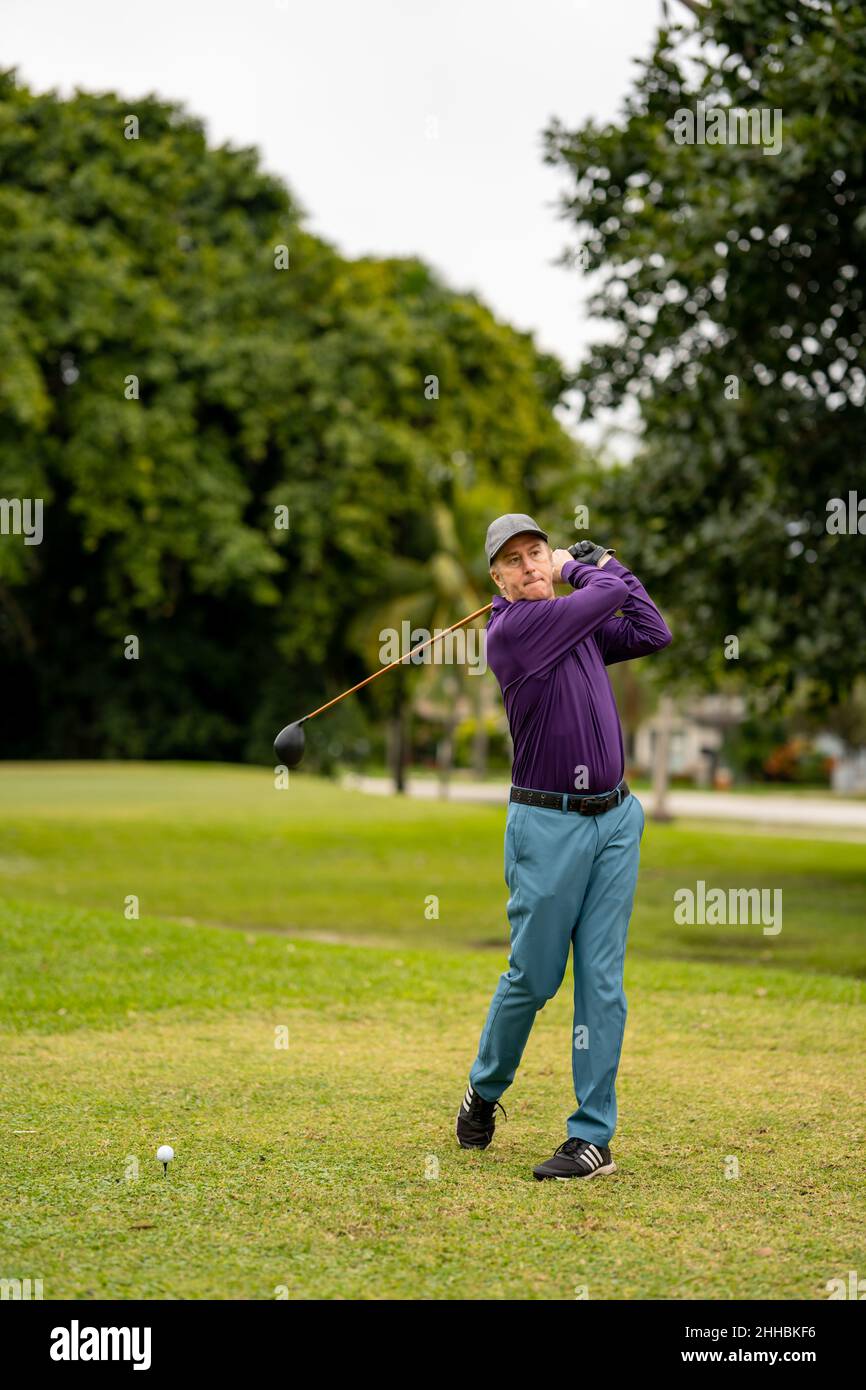 Golfer swinging on the golf course Stock Photo