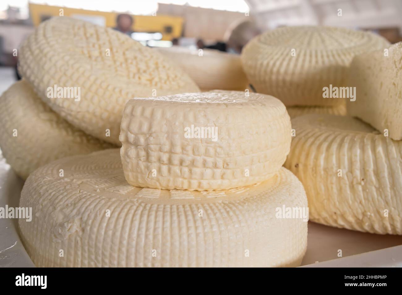 Closeup of piles of round homemade traditional cheese in the market in Georgia Stock Photo