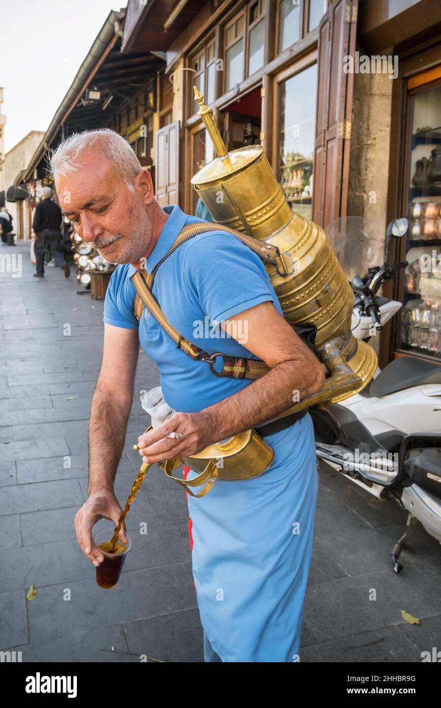 A street vendor pours a glass of traditional drink made with licorice root, Gaziantep, Turkey Stock Photo