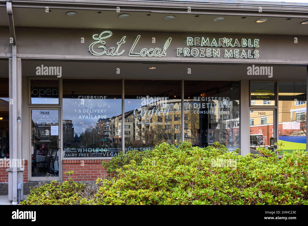 MERCER ISLAND, WA, USA – JANUARY 22, 2022: Downtown Mercer Island, closeup of Eat Local storefront, reflection of new buildings in window Stock Photo