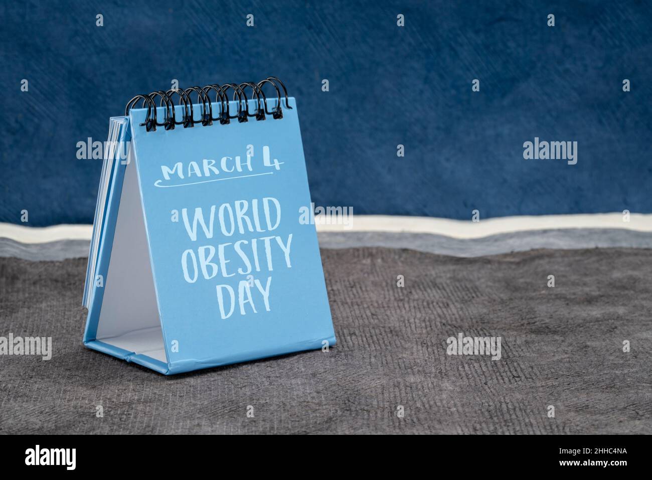 World Obesity Day, March 4 reminder - handwriting in a desktop calendar against abstract landscape, promoting practical solutions to end the global ob Stock Photo