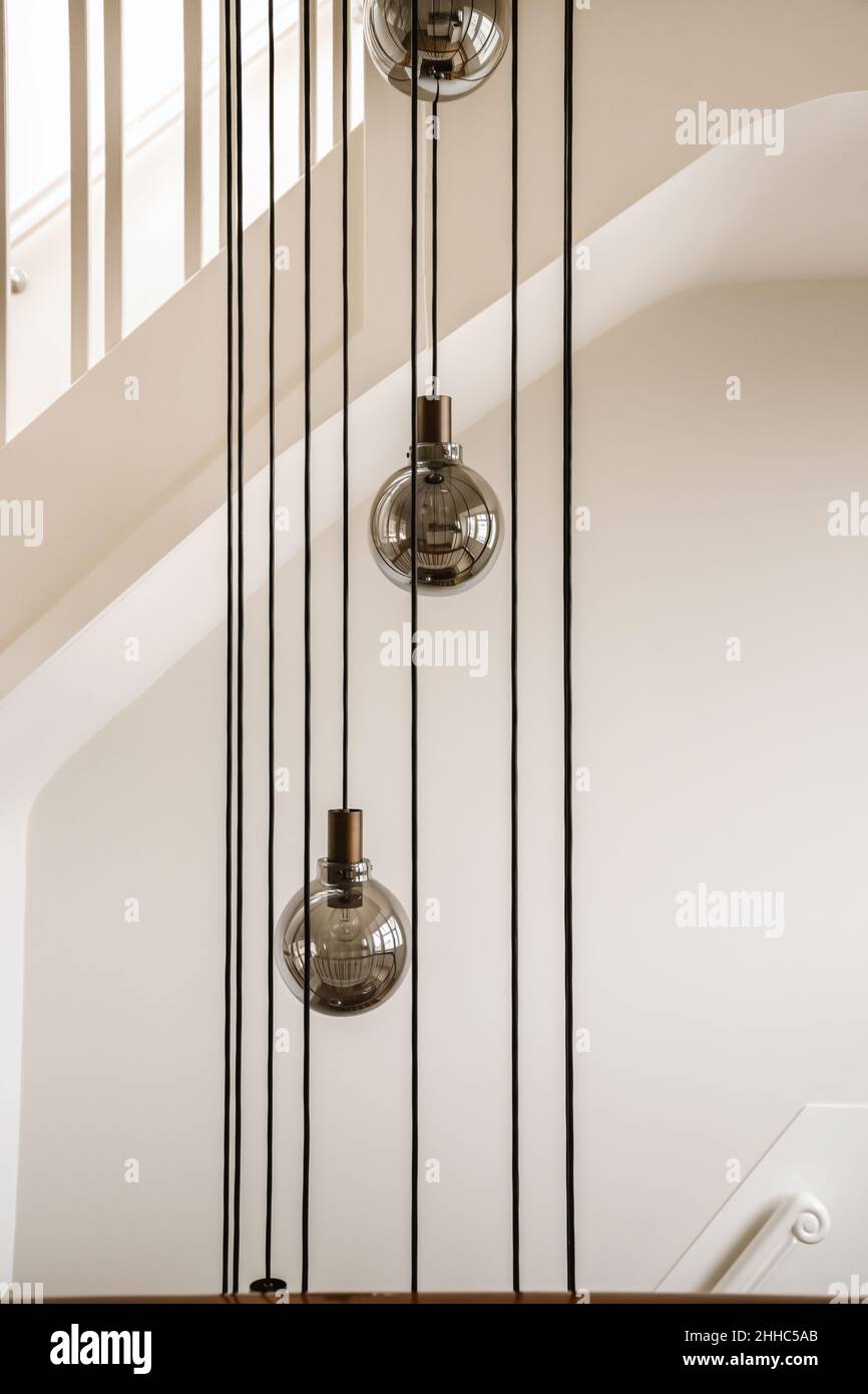 Amazing design of a white staircase with hanging chandeliers Stock