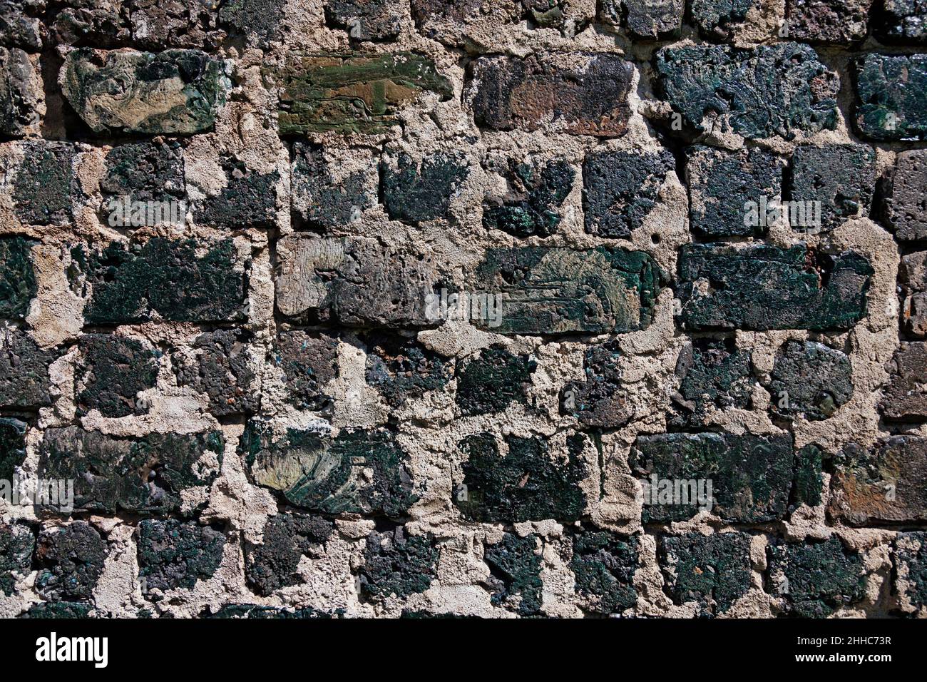 very old black brick wall with large cracks Stock Photo