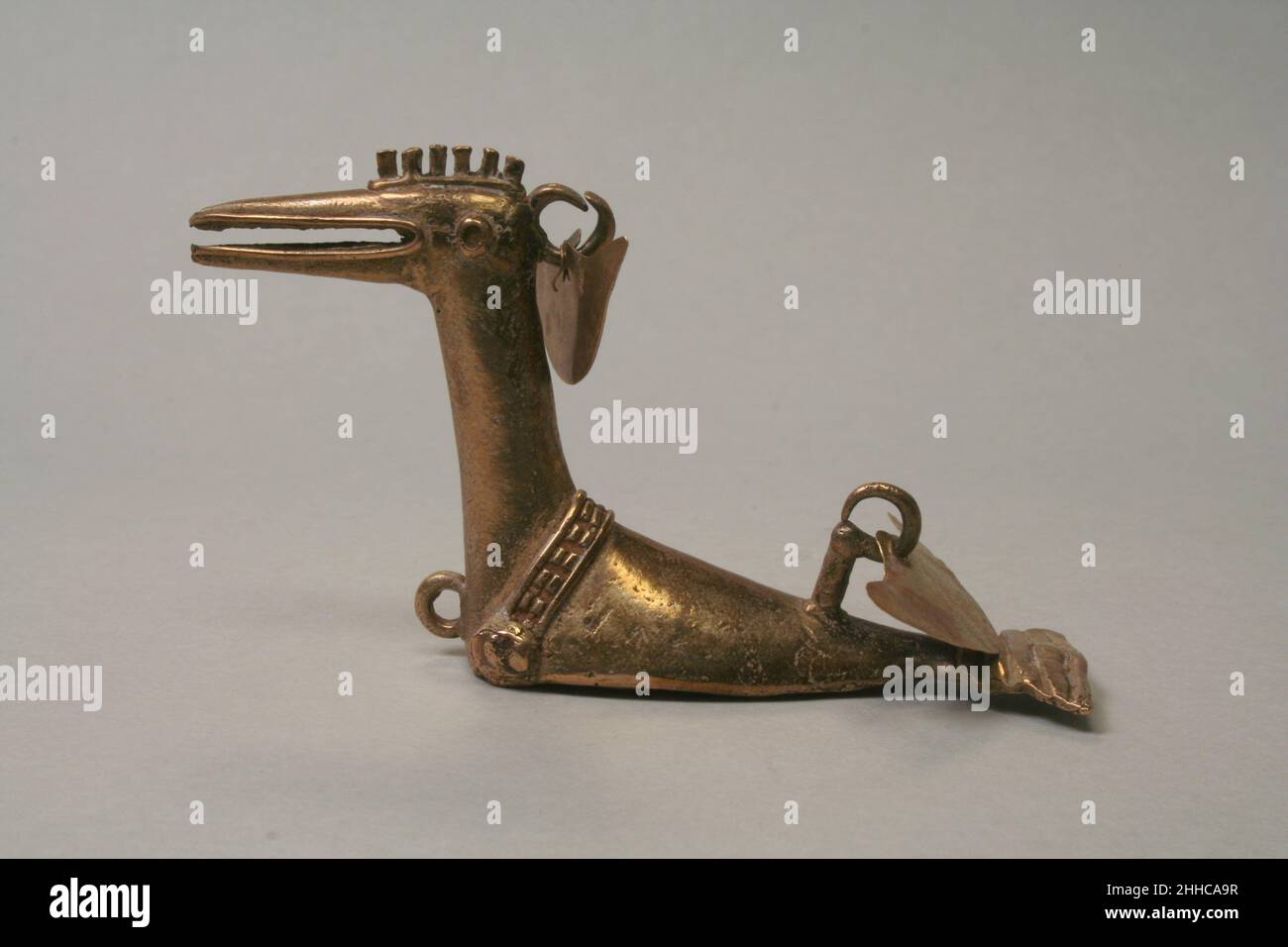 Bird Pendant 300 B.C.–A.D.700 Early Quimbaya Technical note: Optical microscopy and XRF conducted in 2017. This pendant in the shape of a bird was primarily produced through lost wax casting. Made of an alloy of gold, it depicts a stylized bird with identifying features of a head, neck, body, and tail. The lower areas of the bird, its abdomen and limbs, are not shown. Depicting the bird in this way suggests that it is 'posad[a] en agua' ('at rest in water'), as Pérez de Barradas (1966, 106) inferred for a similar avian pendant. All of the design features of this pendant were originally made in Stock Photo