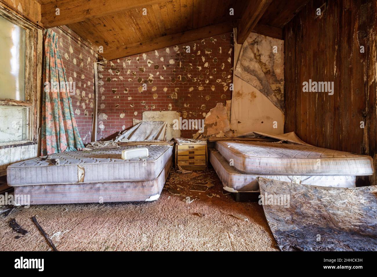 An abandoned motel room with extreme rot starting to take hold. Stock Photo