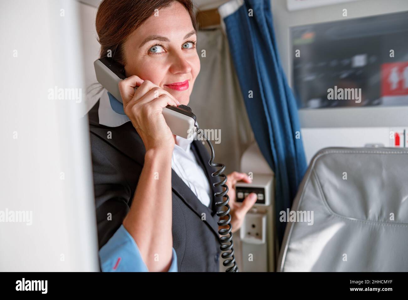 Female stewardess talking on telephone in airplane Stock Photo Alamy