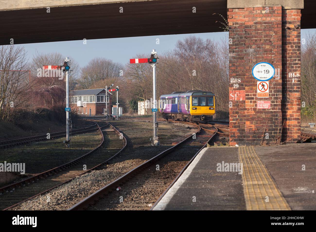 Northern Rail class 142 pacer train ( railbus )142011 with mechanical railway signals and the large signal box at  Bridlington. Stock Photo