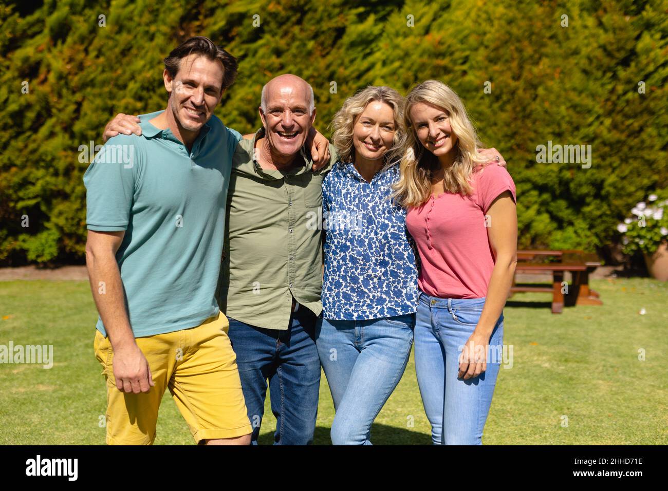 Portrait of caucasian two generation family smiling while standing together in the garden Stock Photo