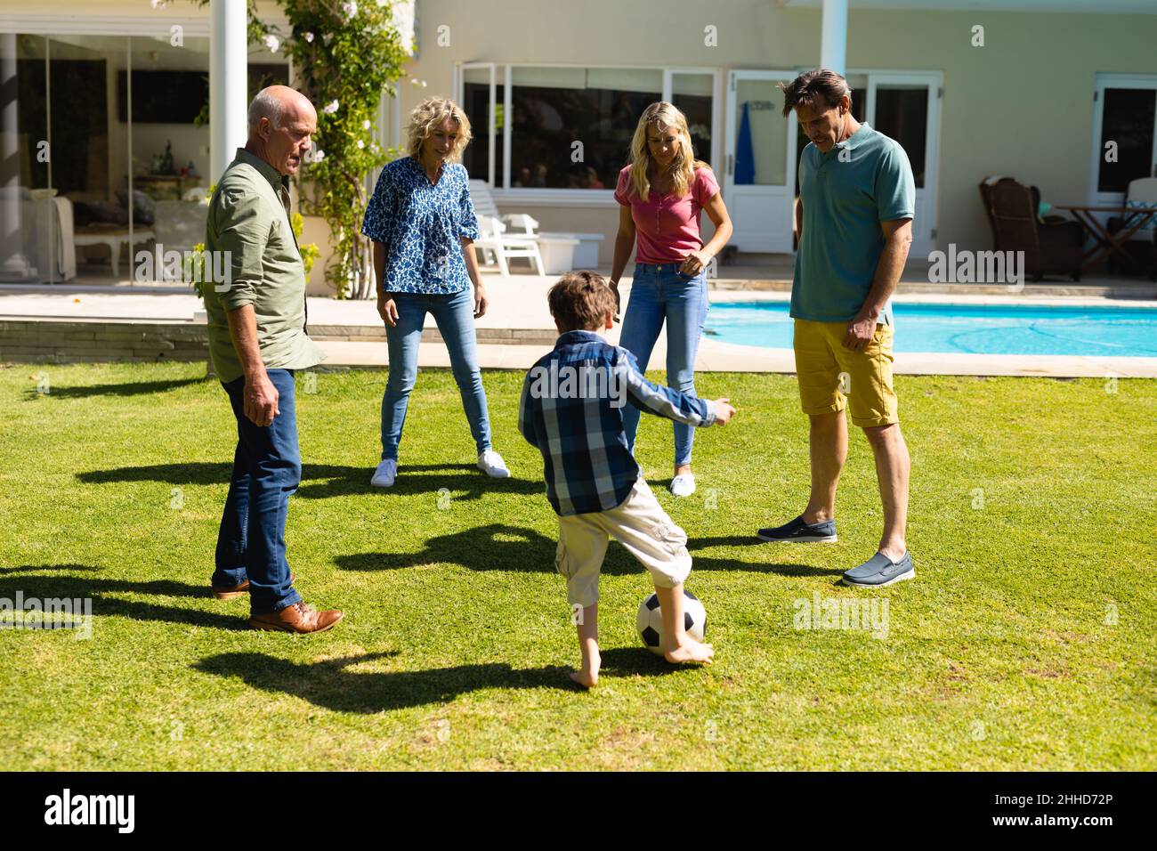 Caucasian three generation family playing football together in the garden Stock Photo