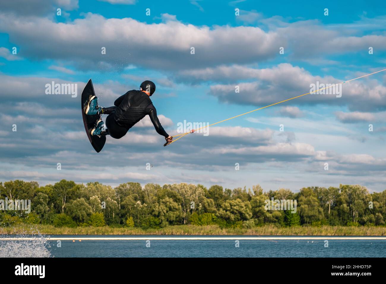 Wake Riders Experienced wakeboard rider towed on cable jumping and spinning in air ...