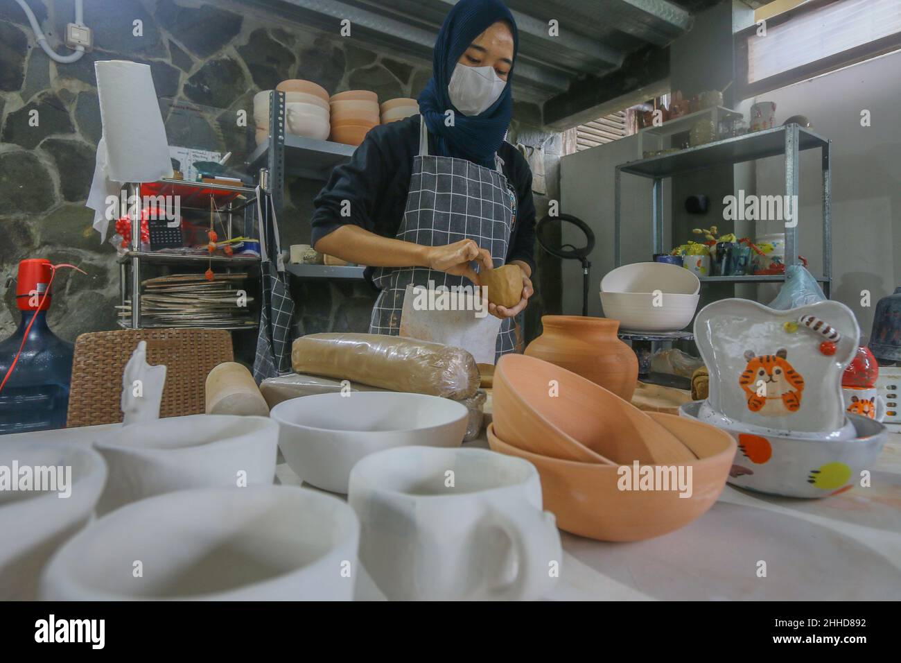 female artist makes pottery from clay at Mini Pottery Studio, Kota