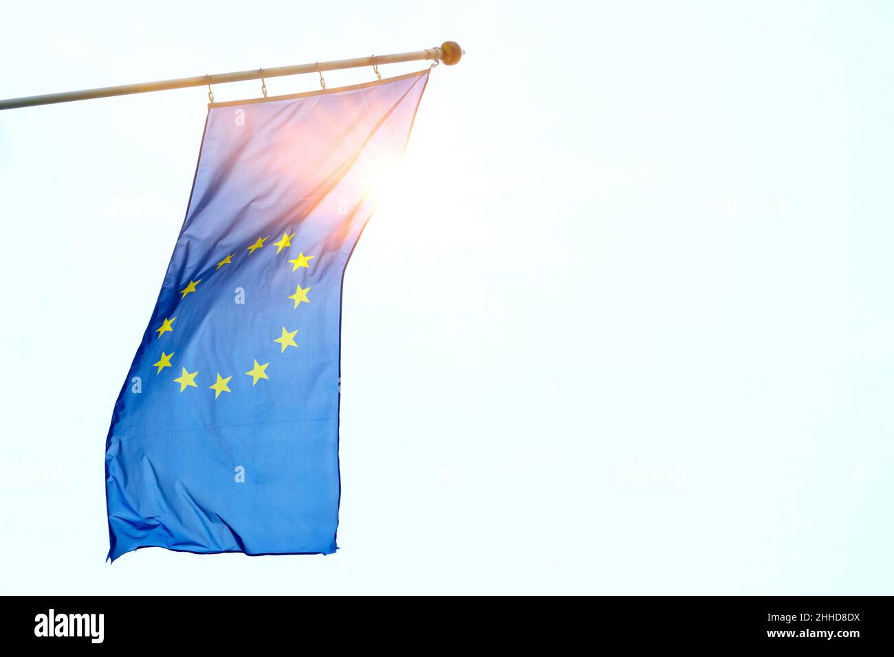 EU flag of European Union with sunbeam against blue sky, space for text Stock Photo