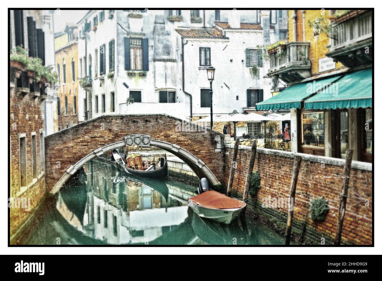 Romantic Venetian canals. Old narrow streets of Venice. Gondolas and bridges. Retro styled picture. Italy Stock Photo