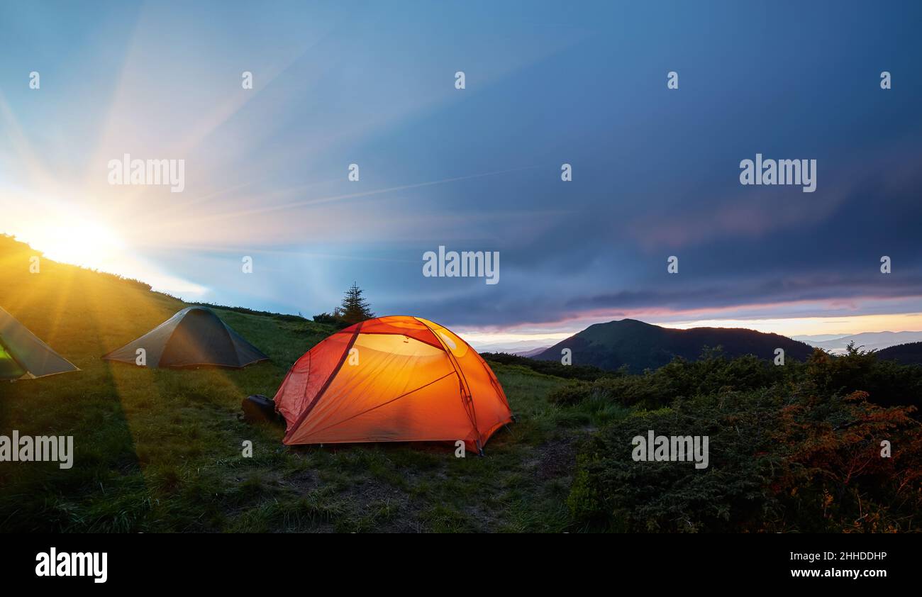 Illuminated orange camping tent under moon at night Stock Photo - Alamy