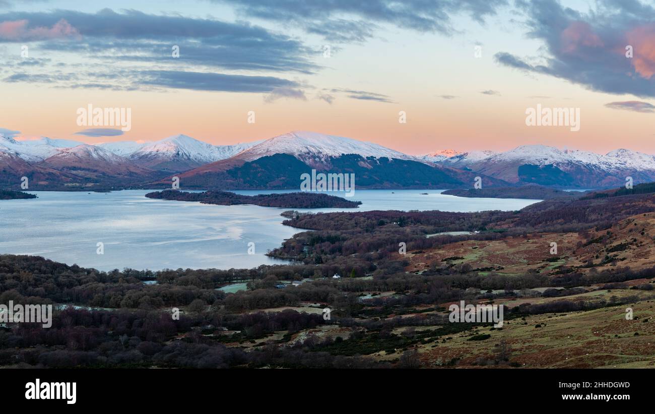 sunrise view from Conic Hill of Loch Lomond the island of Inchlonaig and the Luss Hills including Beinn Dubh in winter - Scotland, UK Stock Photo