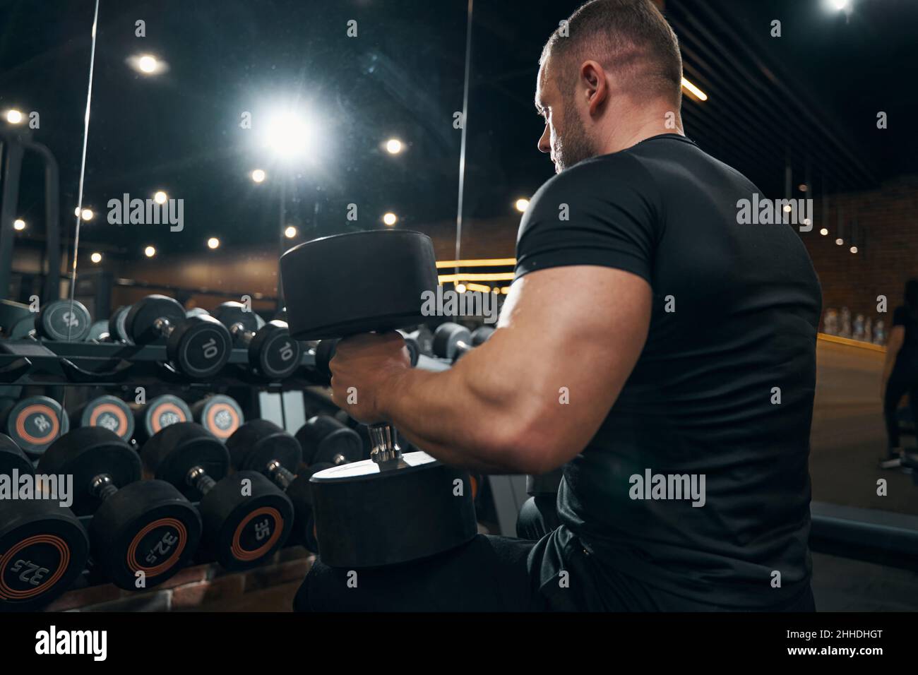 Male bodybuilder working out from seated position Stock Photo - Alamy