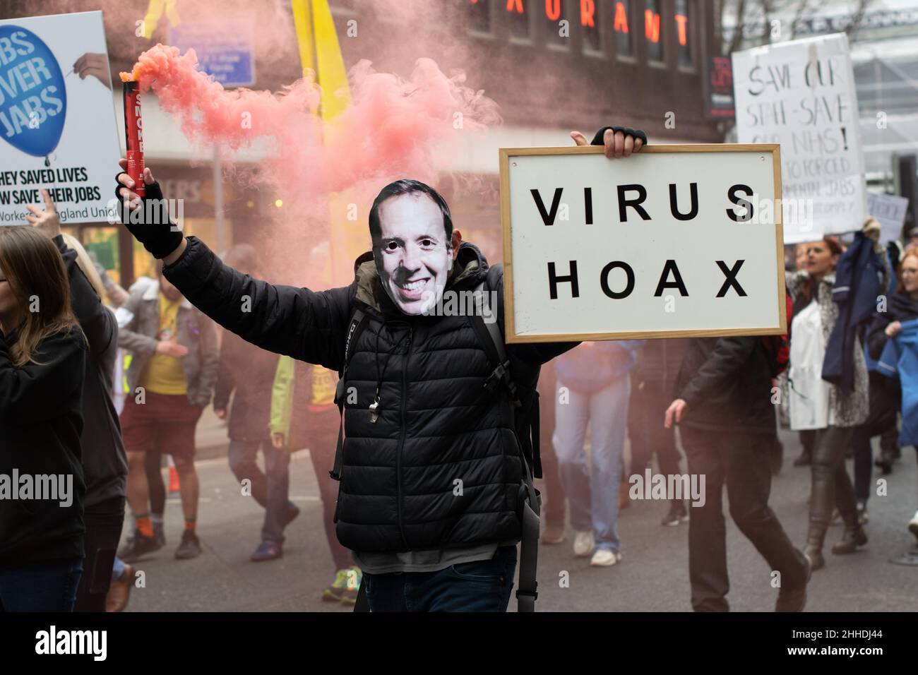 Anti Vax protest. Protester holding sign text Virus Hoax. Deansgate, Manchester UK Stock Photo