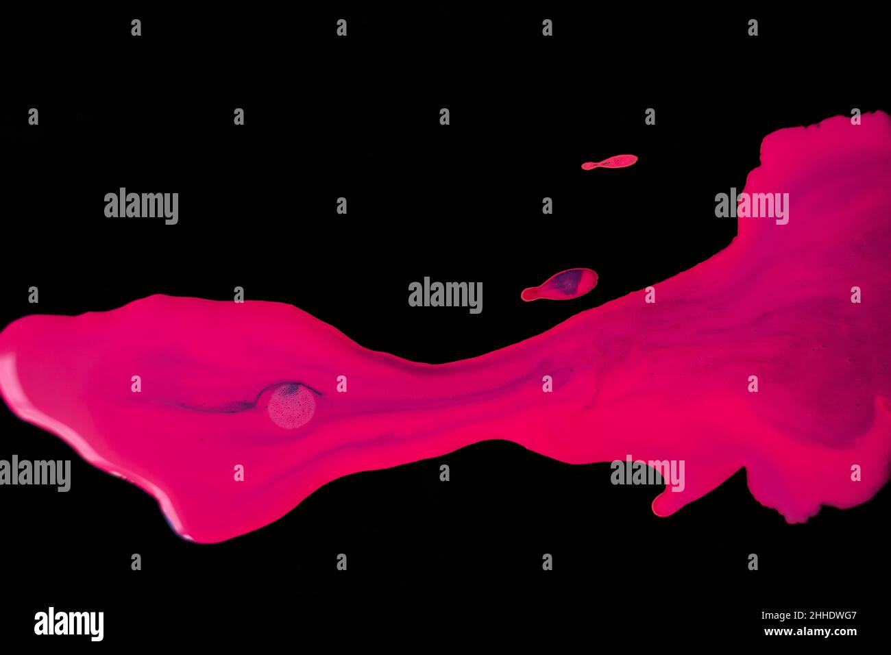 Neon Pink and purple wet paint splatter on black isolated background