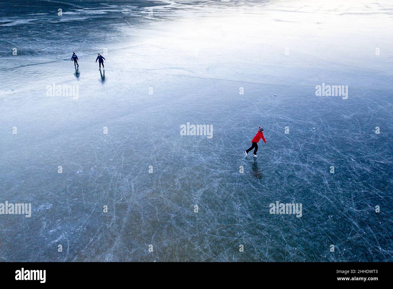 People ice skating on frozen intermittent lake Cerknica, Slovenia Stock Photo