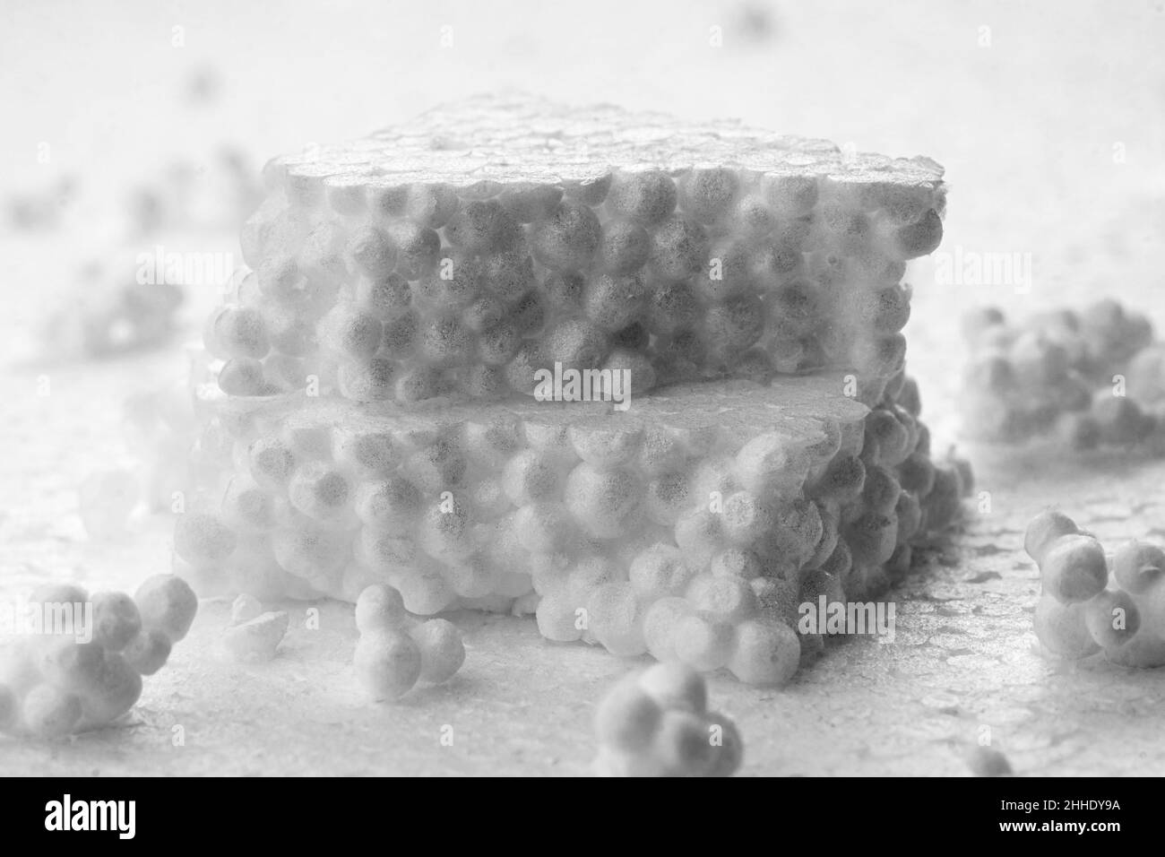 Broken pieces of white styrofoam are stacked on the sheet of white
