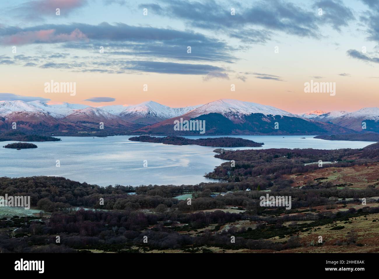 sunrise view from Conic Hill of Loch Lomond the island of Inchlonaig and the Luss Hills including Beinn Dubh in winter - Scotland, UK Stock Photo