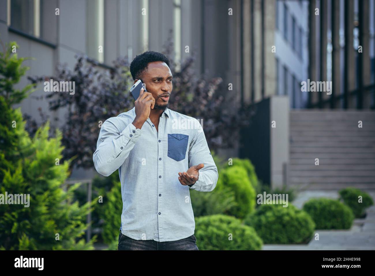 Angry and serious african american businessman talking on the phone ...